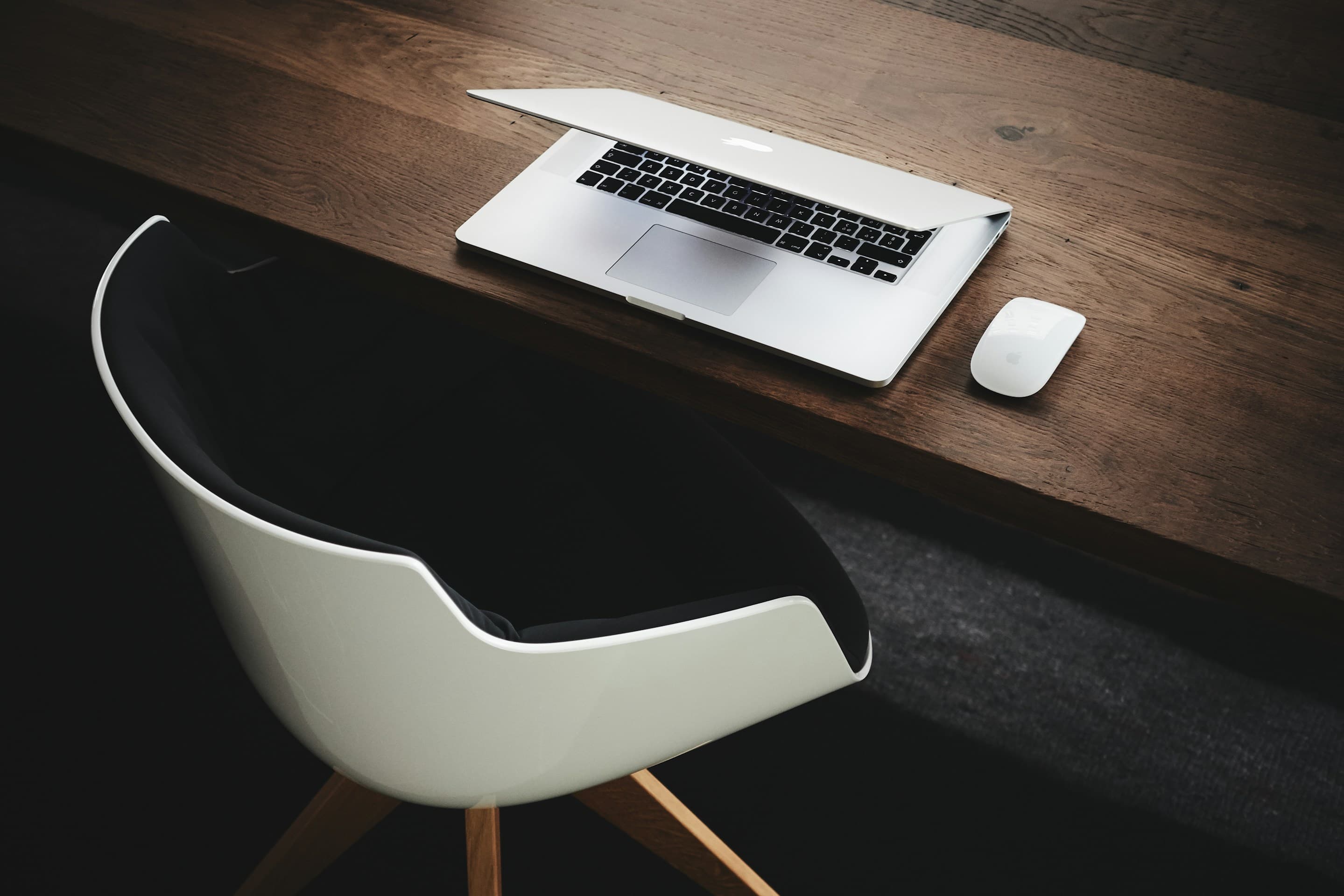 Laptop and mouse on a wooden desk